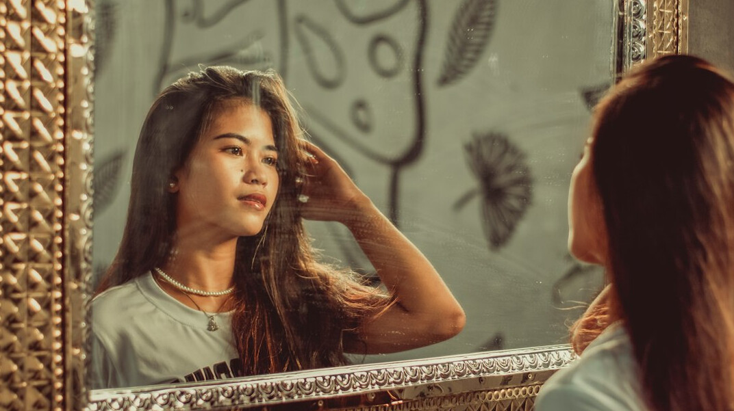 woman changing hairstyle in mirror